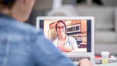 A doctor having a virtual consultation with a patient using a laptop 